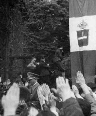 Adolf Hitler greets the crowd in front of the Italian embassy in Vienna
